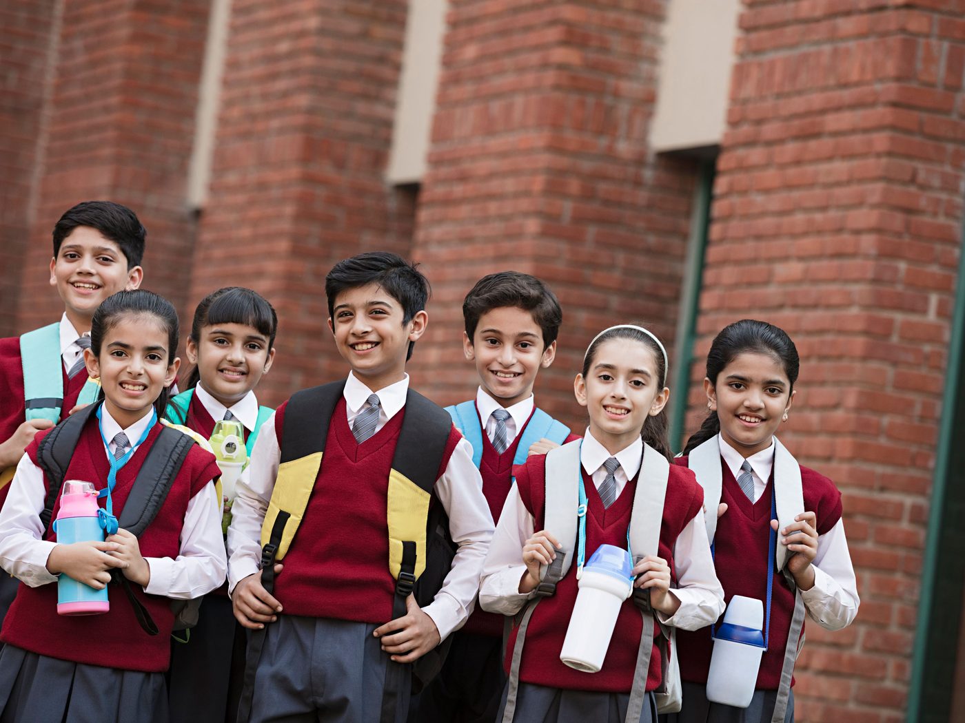 A smiling group of students in school uniform outside their school; Schoolcanvas has served schools since 2009