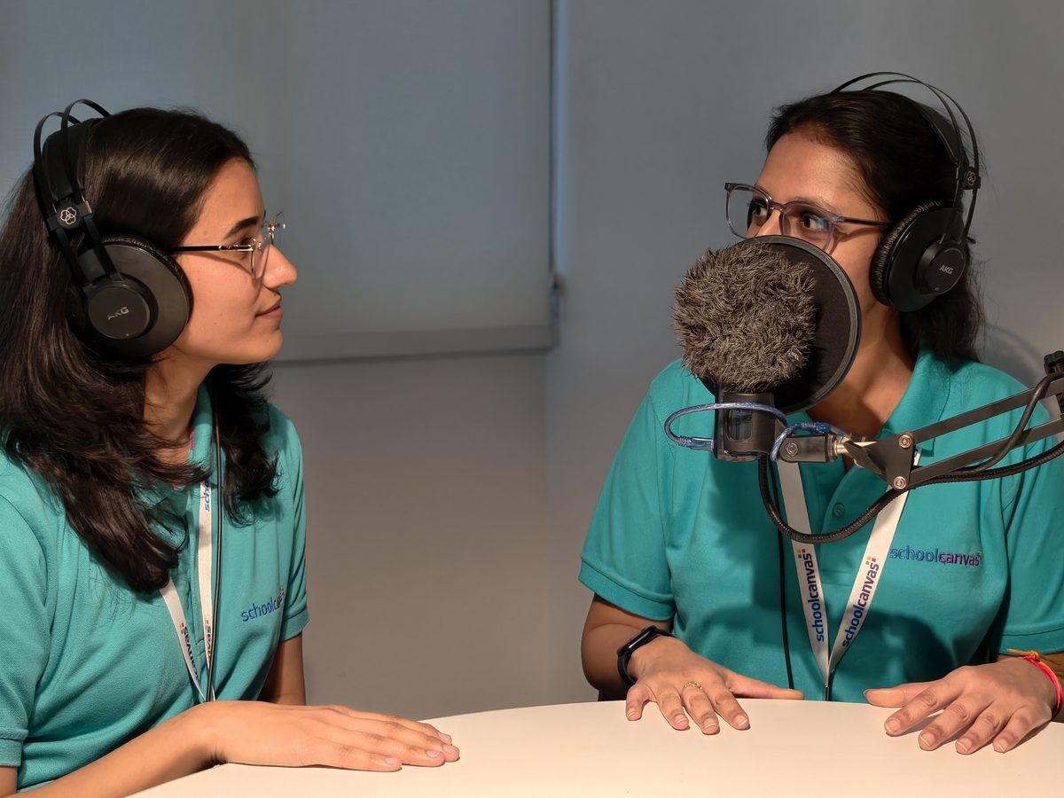 Two members of the Assist team recording a lesson video in the studio with headphones and microphones