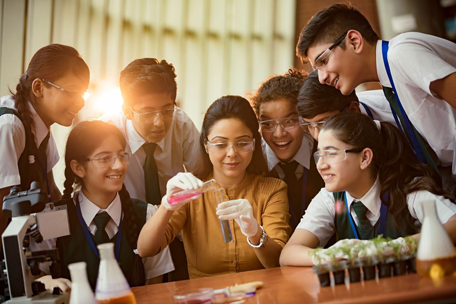 Senior students preparing for boards and JEE or NEET, working on a chemistry experiment with their teacher