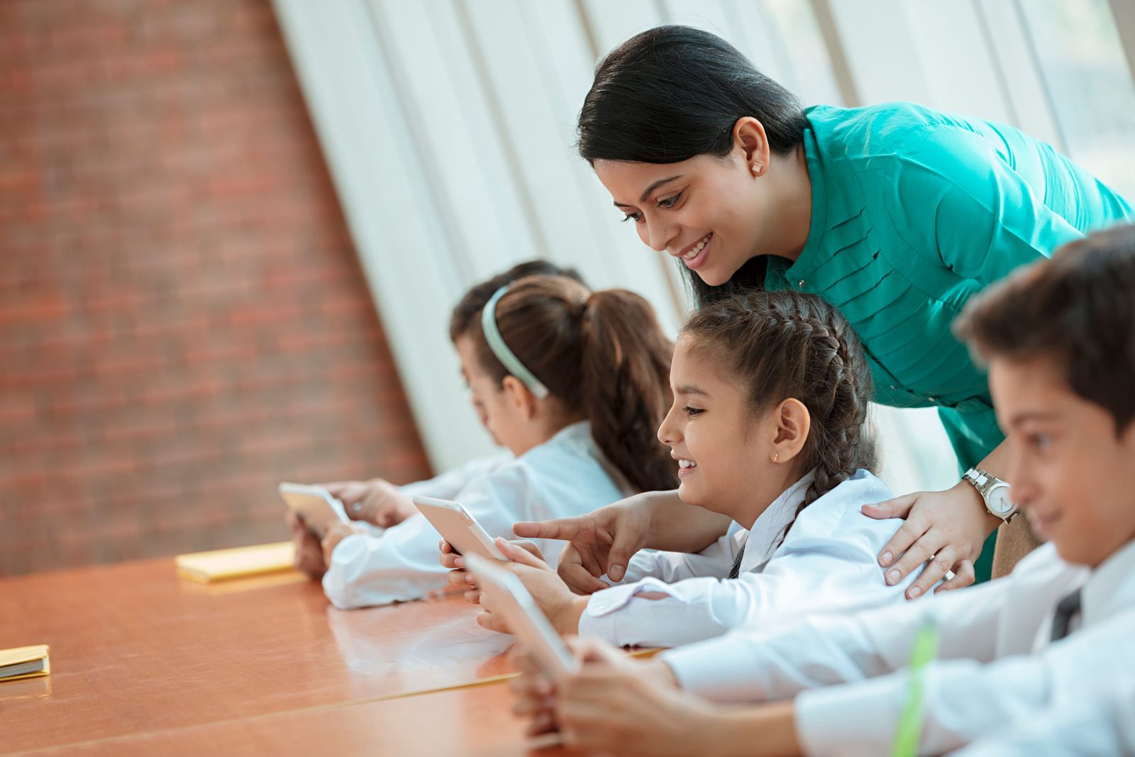 A teacher helping students with their work in class, the everyday teaching that appraisals look at