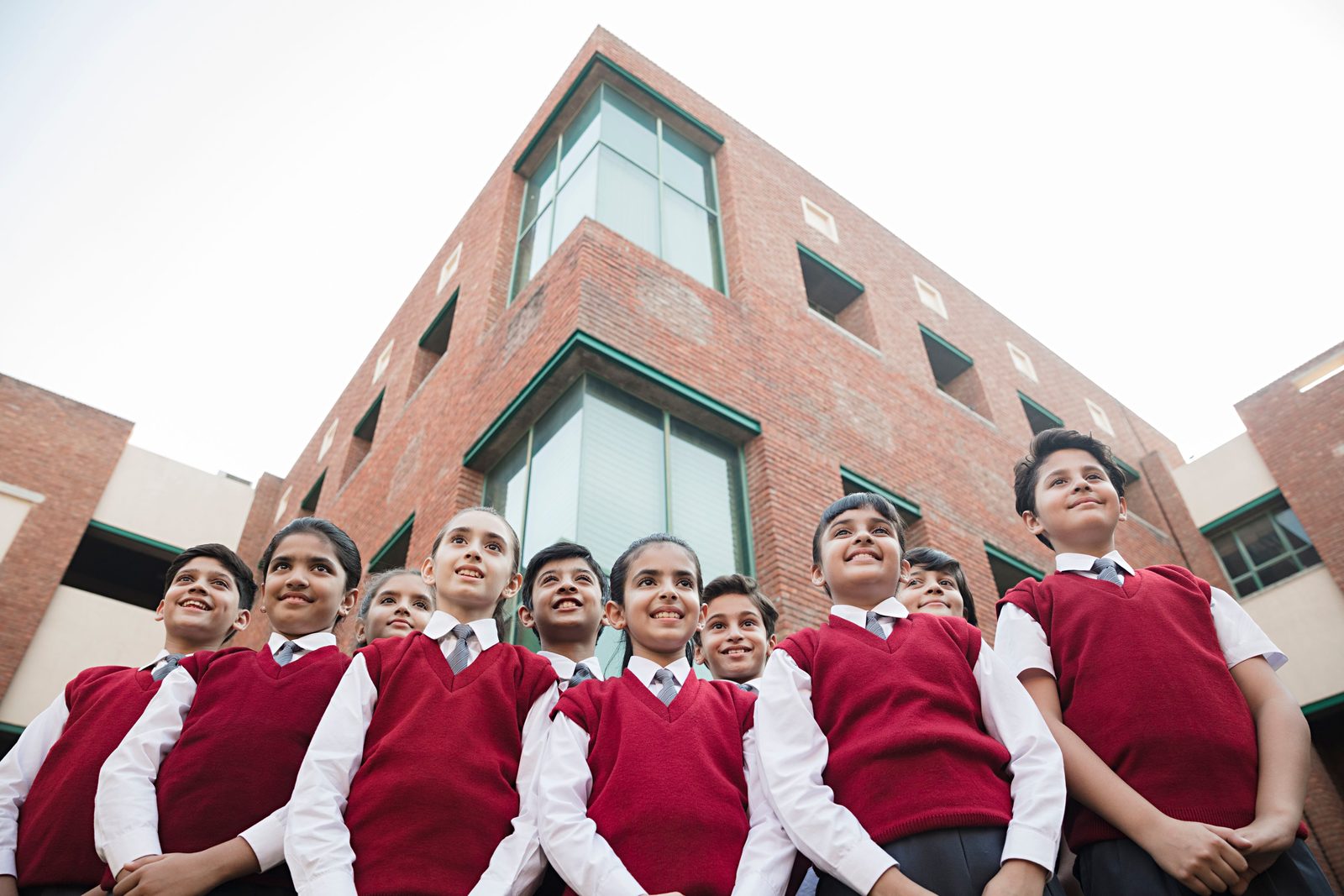 Students in uniform standing in front of their school building